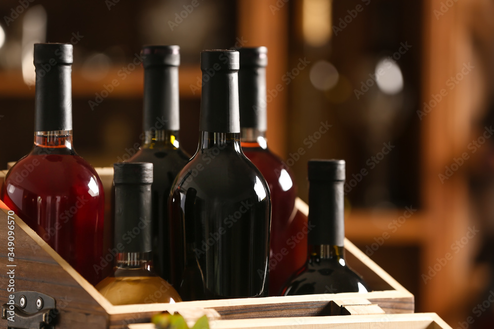 Box with bottles of tasty wine in cellar