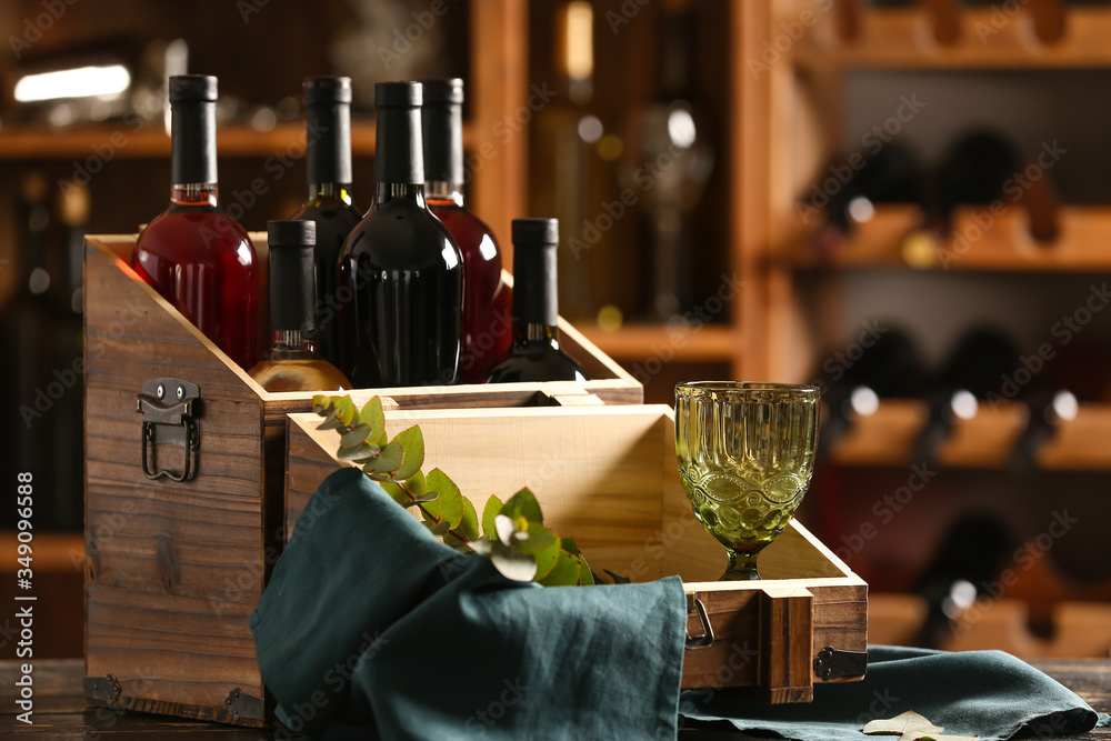 Box with bottles of tasty wine in cellar