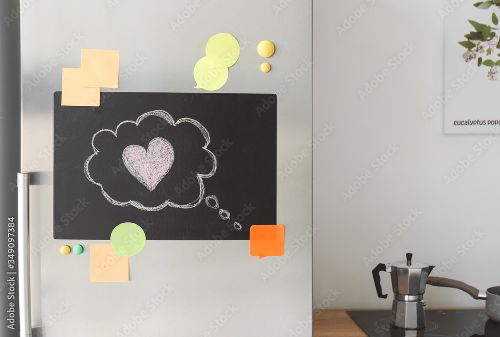 Chalkboard on door of modern refrigerator in kitchen