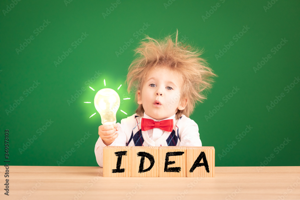 Bright idea! Happy child student against green chalkboard