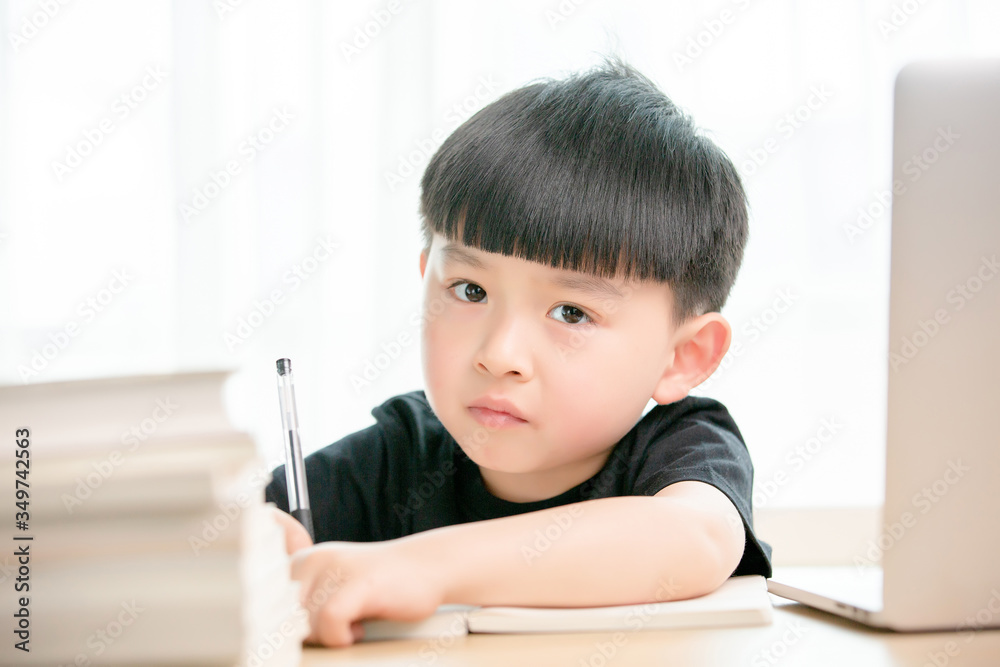 Asian little boy doing online class
