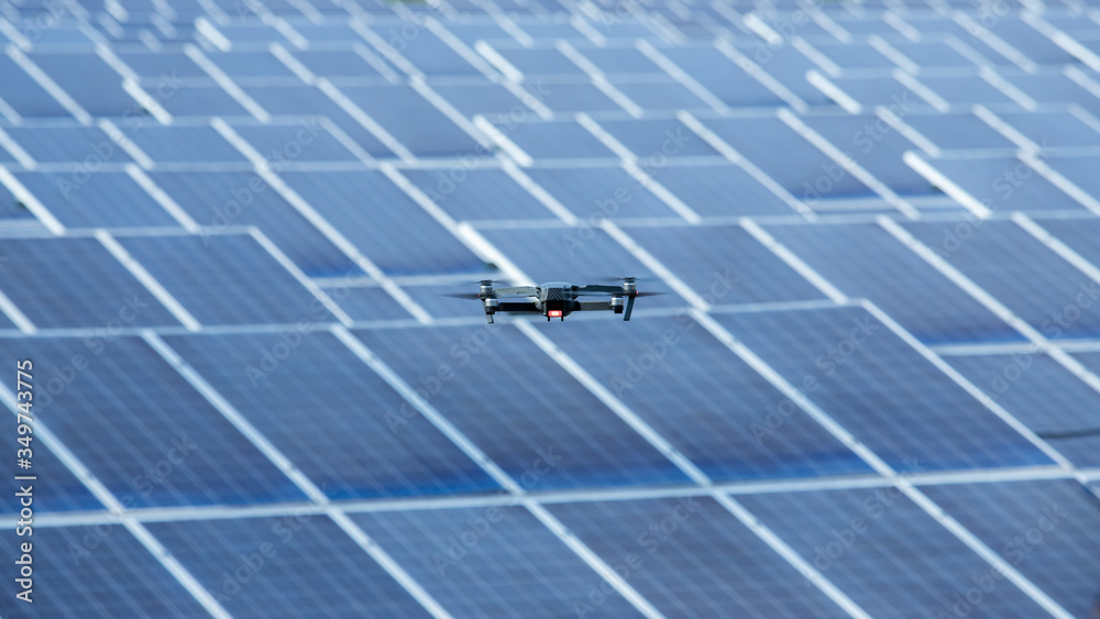 Flying Drone inspection explores the work of solar cell panel with strong sun and sky in solar farm