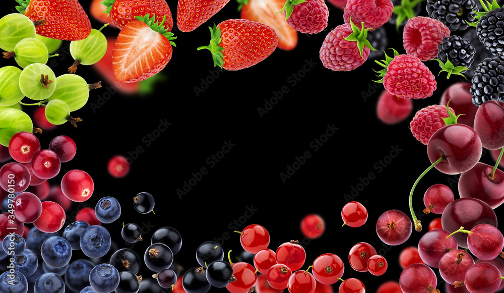 Frame made of different flying forest berries on black background