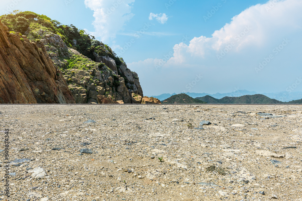 Gravel road and mountain landscape by the sea.