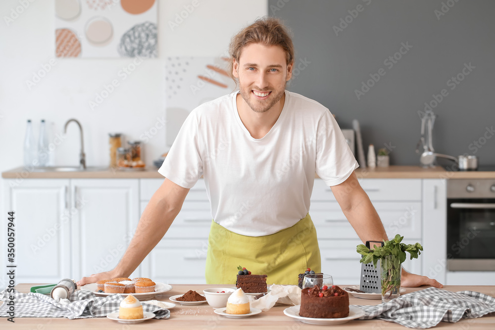 Male confectioner with tasty desserts in kitchen