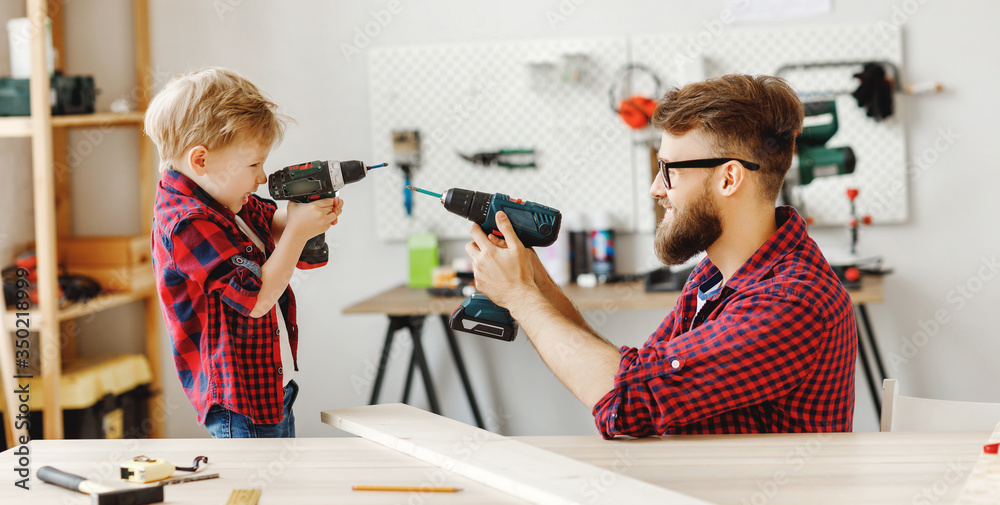 Father and son having fun with drills in workshop.