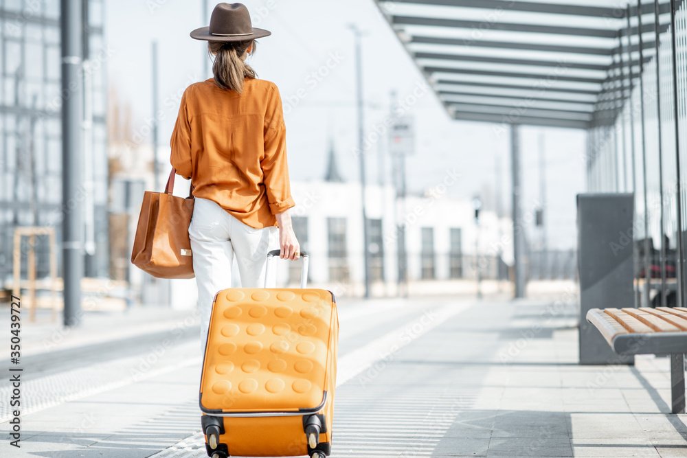 在运输站拿着行李的年轻女性旅行者