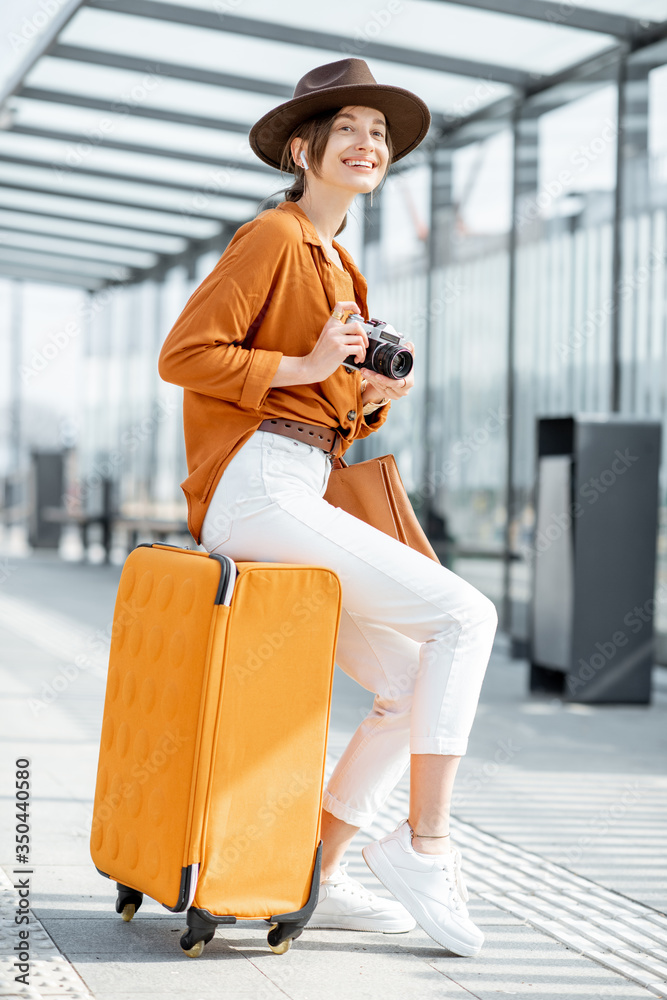 在运输站拿着行李的年轻女性旅行者