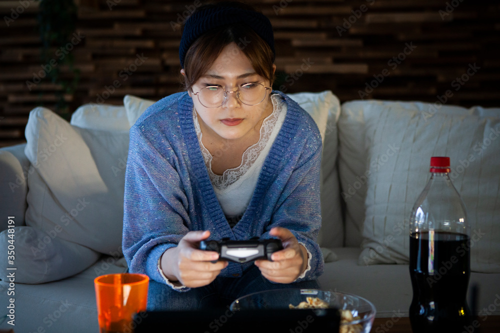 暗い部屋でビデオゲームをする若い女性