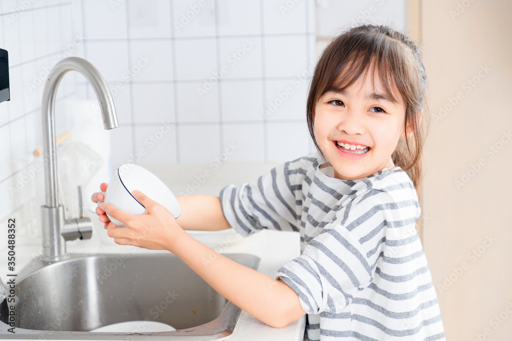 
Asian little girl washing the dishes