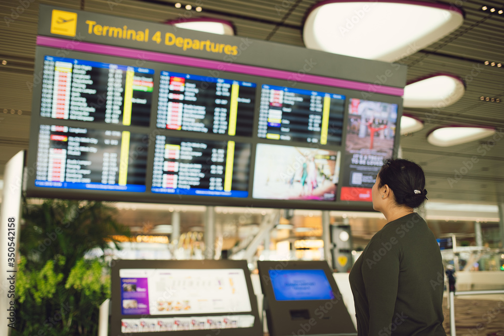 An air traveler views a flight notice board in the departures terminal of Airport