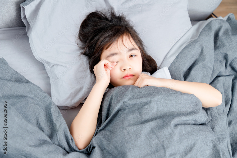 Asian little girl sleeping in bed