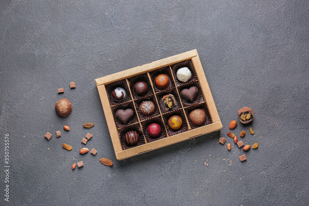 Box with delicious candies on dark background