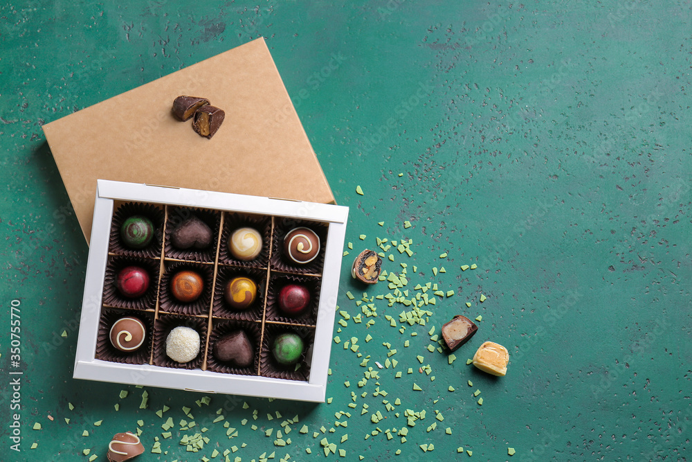 Box with delicious candies on color background