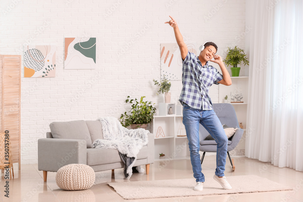 African-American teenager dancing and listening to music at home