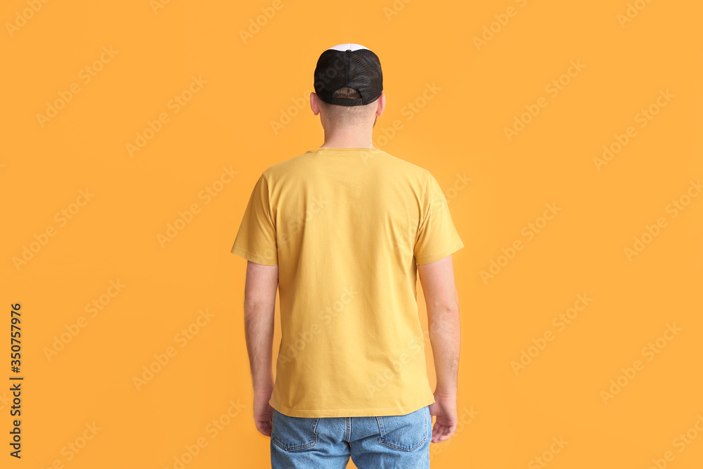 Handsome man in stylish cap on color background