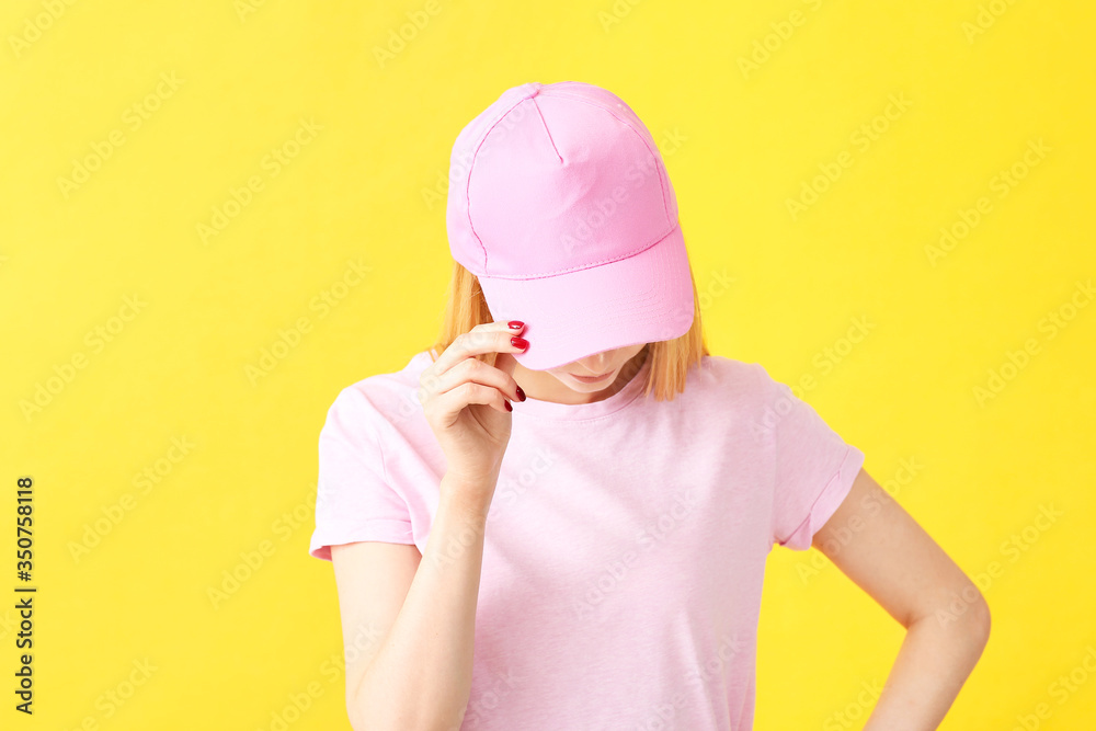 Beautiful young woman in stylish cap on color background