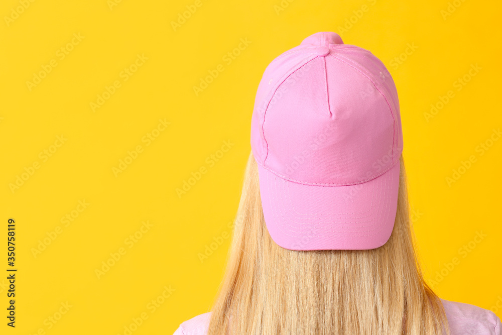 Beautiful young woman in stylish cap on color background