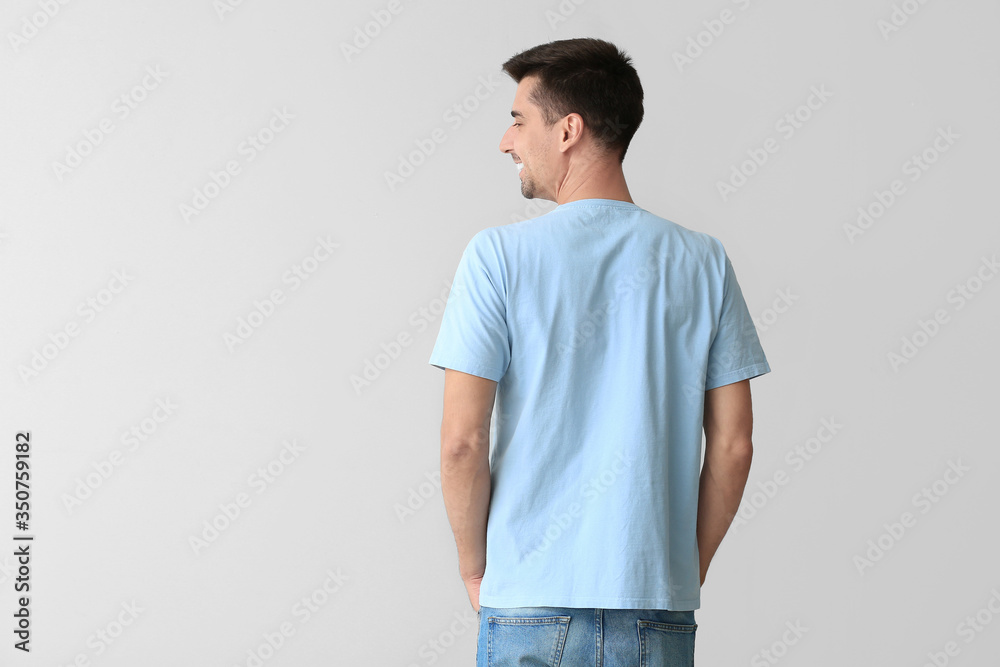 Man in stylish t-shirt on grey background