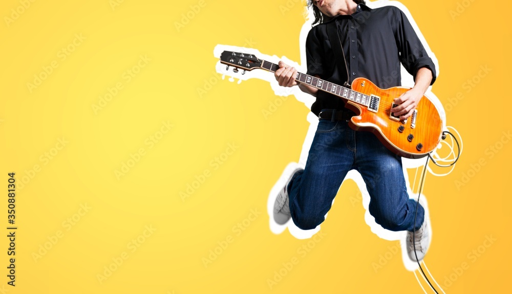 Male guitarist playing music and jump