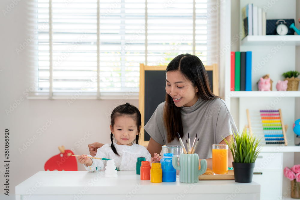 亚洲幼儿园女孩与母亲用丙烯酸水彩画石膏娃娃