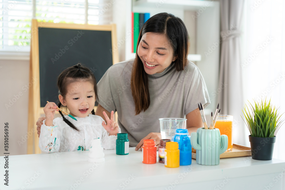 亚洲幼儿园女孩与母亲用丙烯酸水彩画石膏娃娃