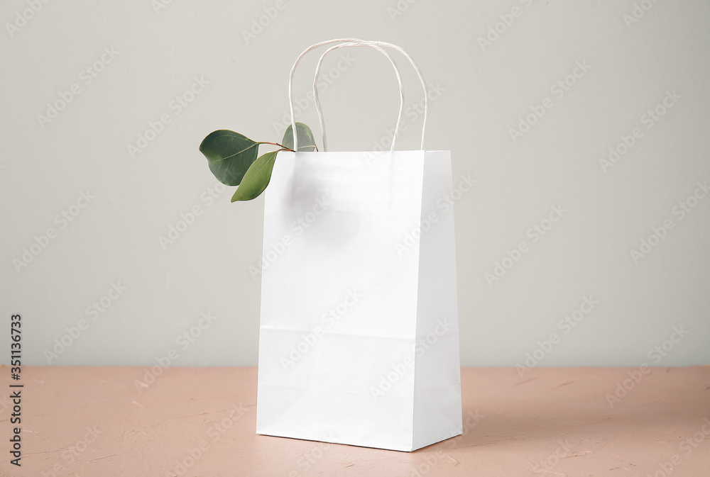 Paper bag on table against light background