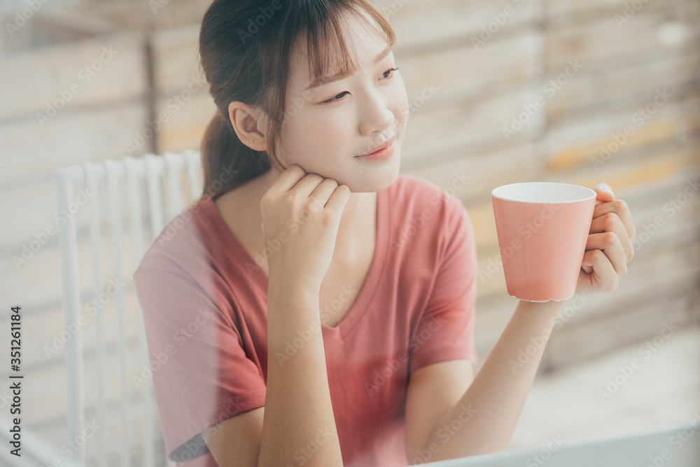 亚洲女性早上在阳台上阅读文件