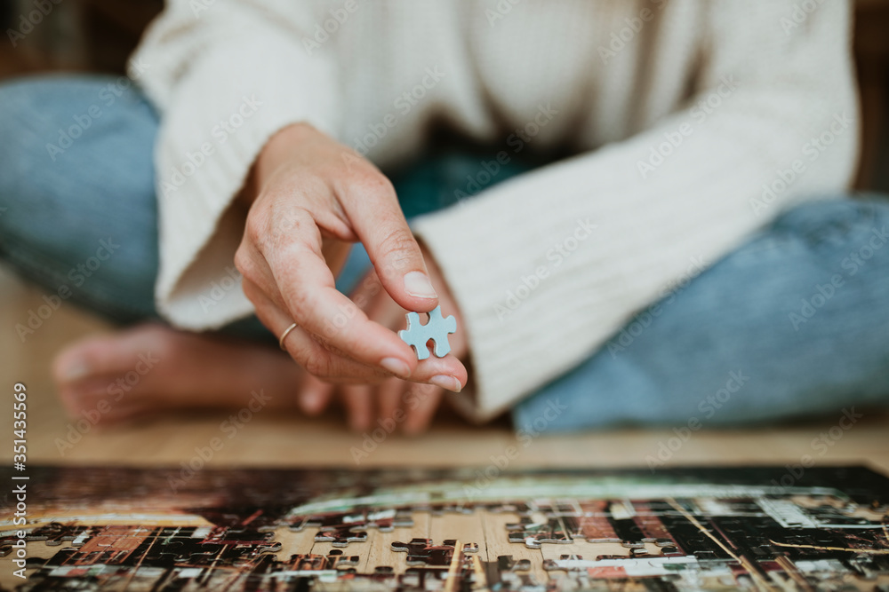 Woman putting together a jigsaw puzzle during self quarantine