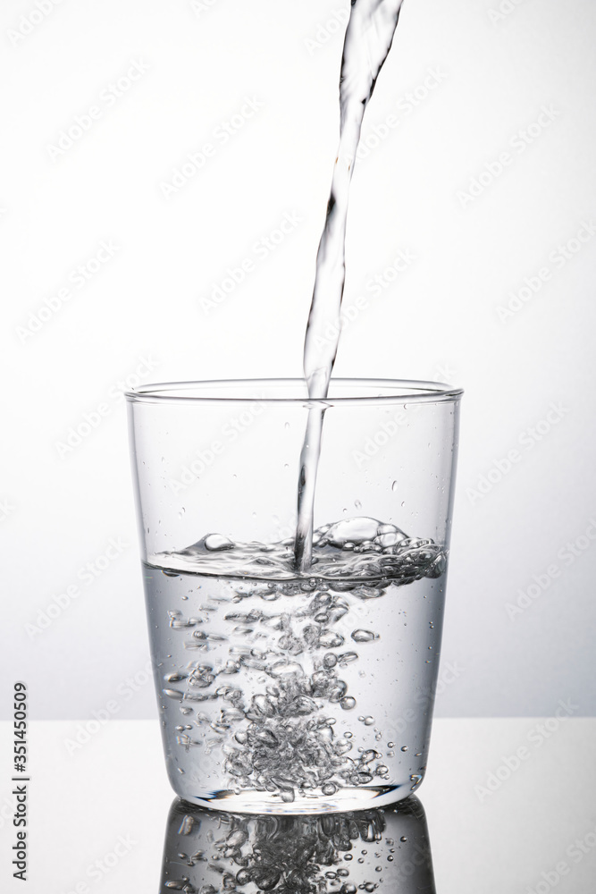 Macro shot of water pouring into a glass