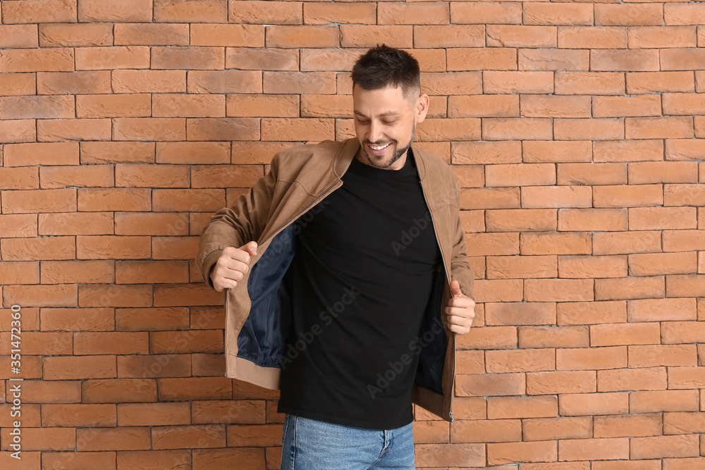 Man in stylish t-shirt near brick wall