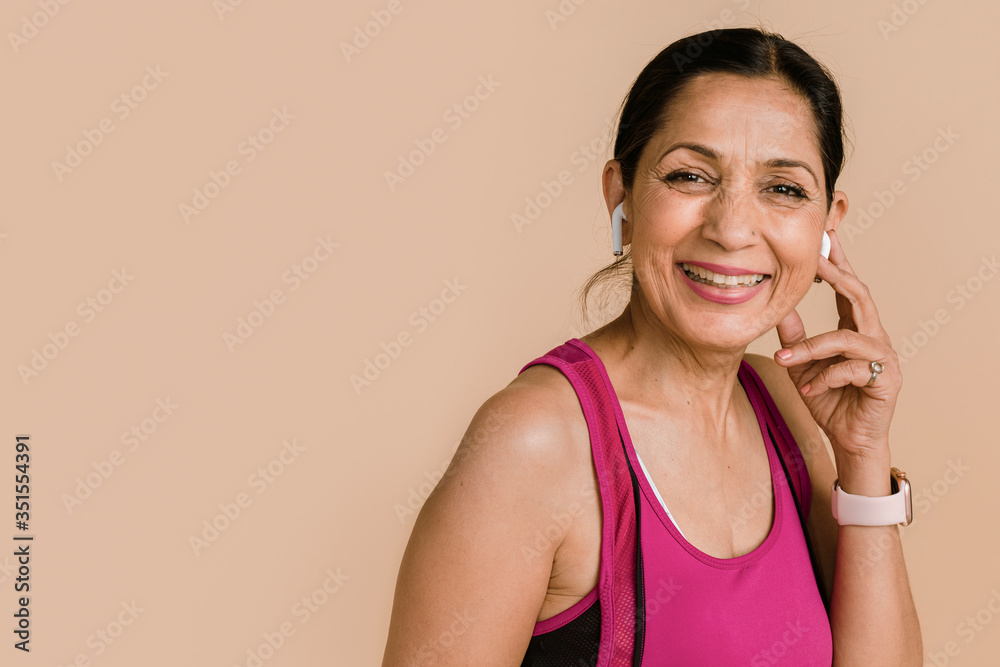 Sporty Indian woman listening to music with wireless earphones