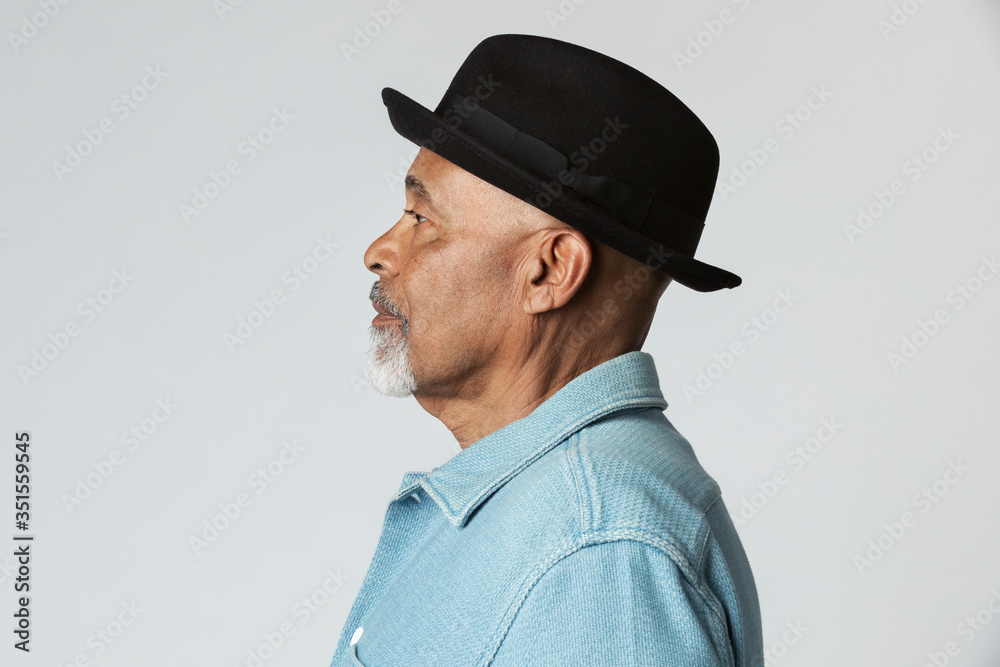 Stylish senior man wearing a black hat in a profile shot