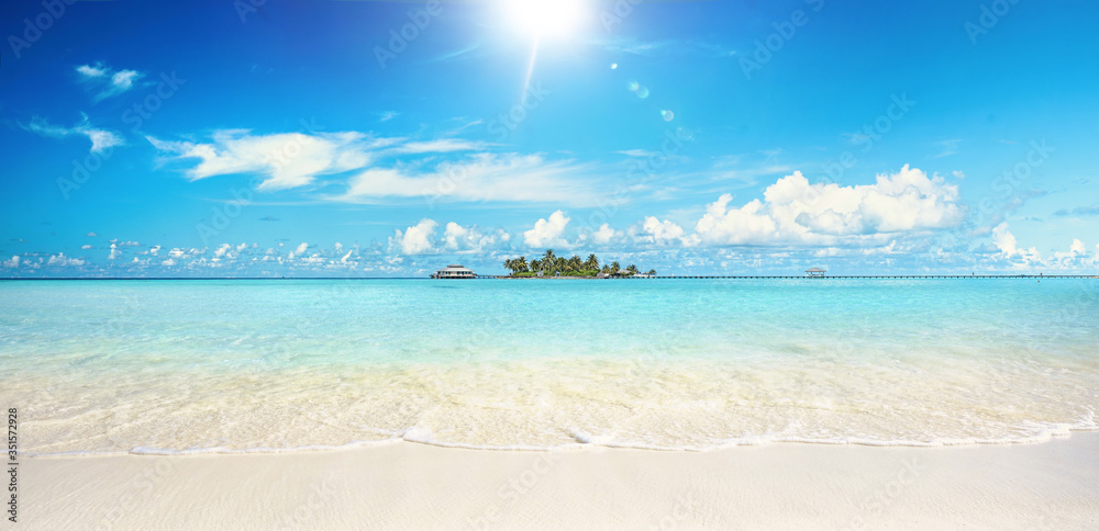 Beautiful sandy beach with white sand and rolling calm wave of turquoise ocean on Sunny day. White c