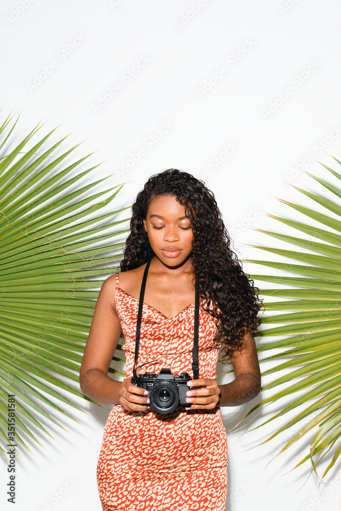 Beautiful black woman with an analog camera