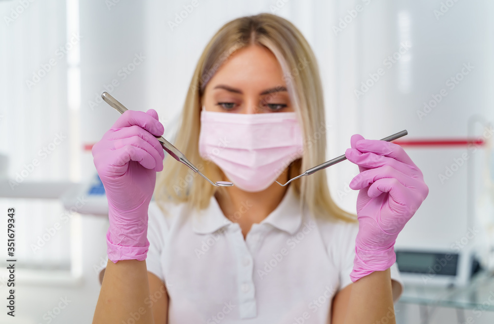 Dentist holds specific medical instruments for examining patient.