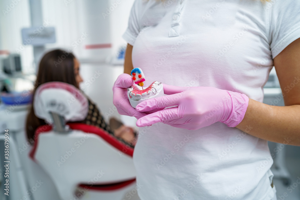 The dentist is holding dentures in his hands. Dental prosthesis in the hands of the doctor close-up.