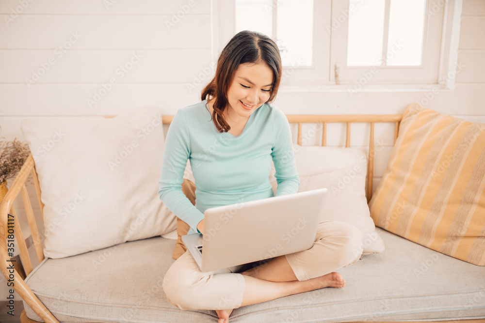 Young asian woman working on laptop at home.