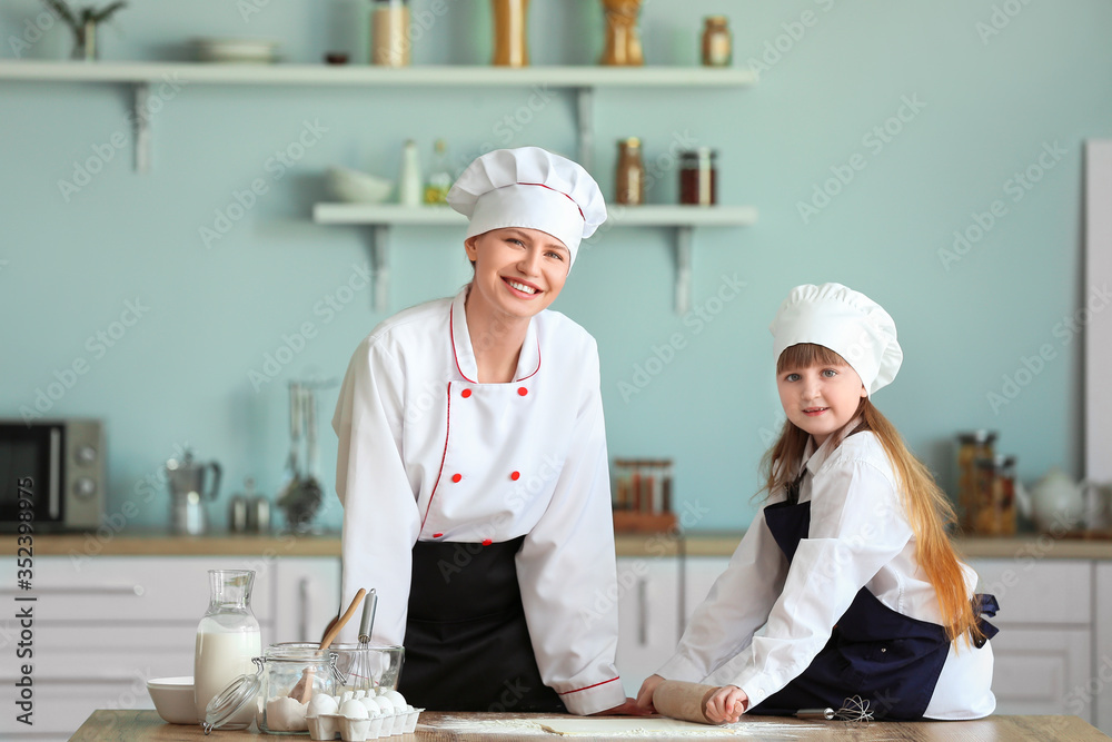 女厨师和她的小女儿在厨房做饭