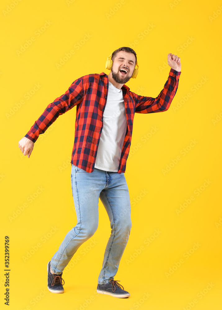 Handsome young man dancing against color background