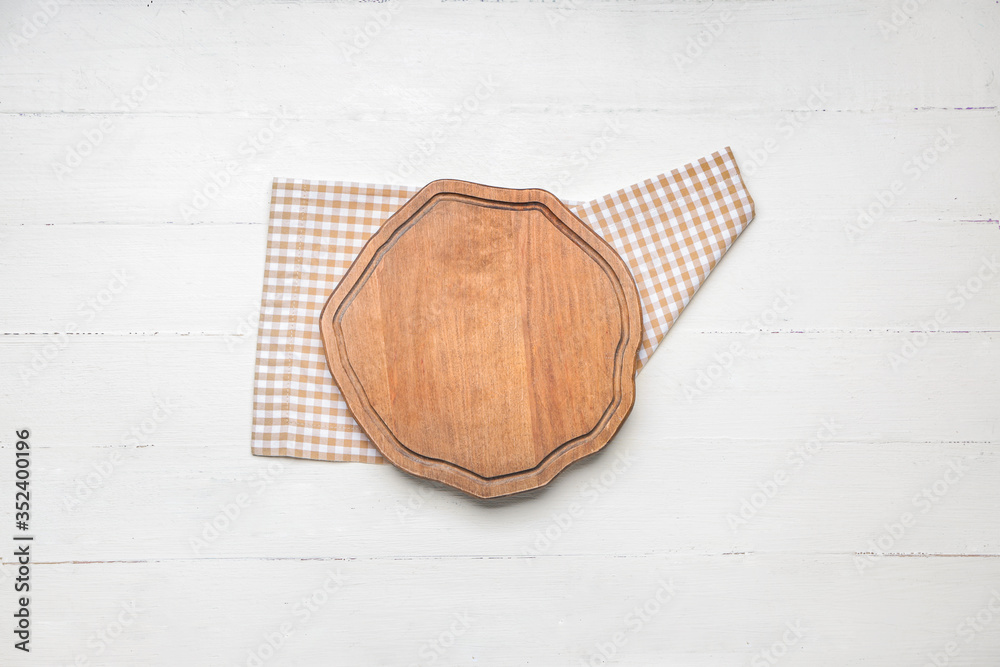 Cutting board with napkin on white wooden background