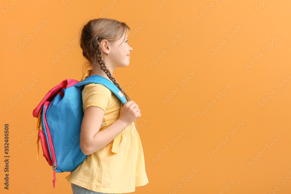 Cute little schoolgirl on color background