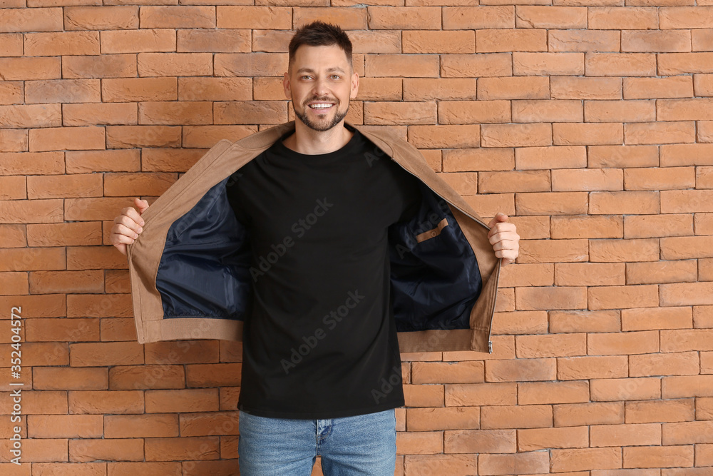 Man in stylish t-shirt near brick wall