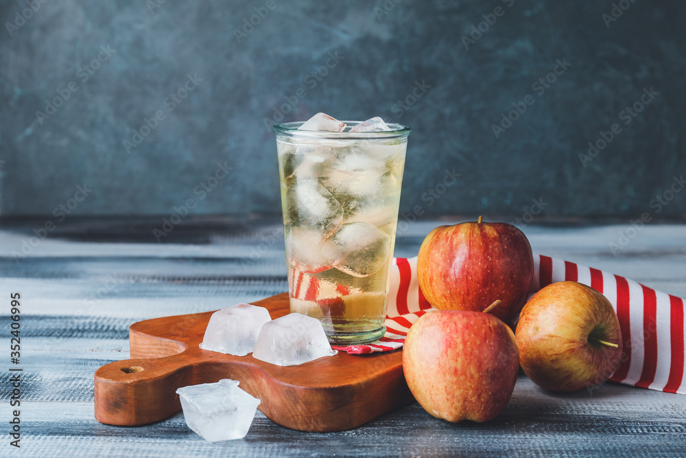 Glass of cold apple cider on table