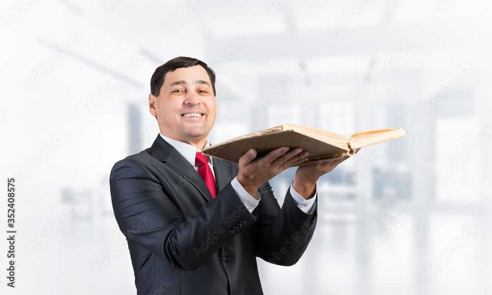 Happy senior businessman holding open book