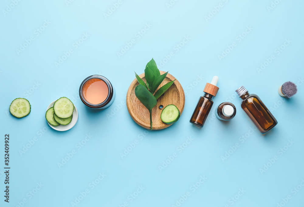 Composition with cucumber and cosmetics on color background