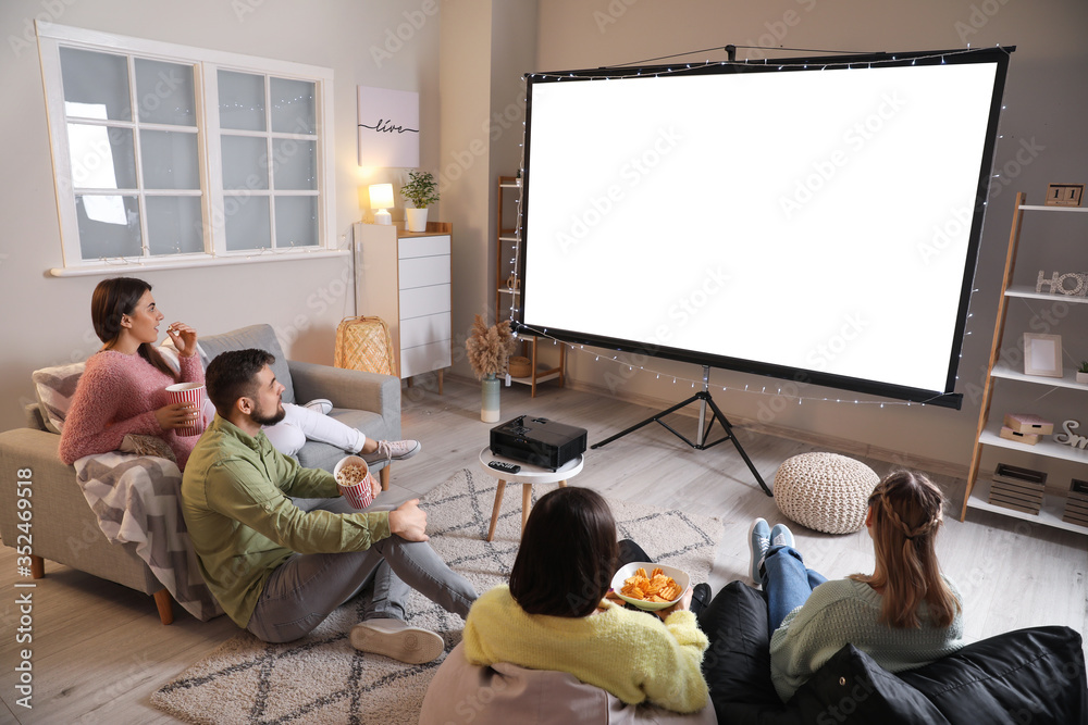 Young friends watching movie at home