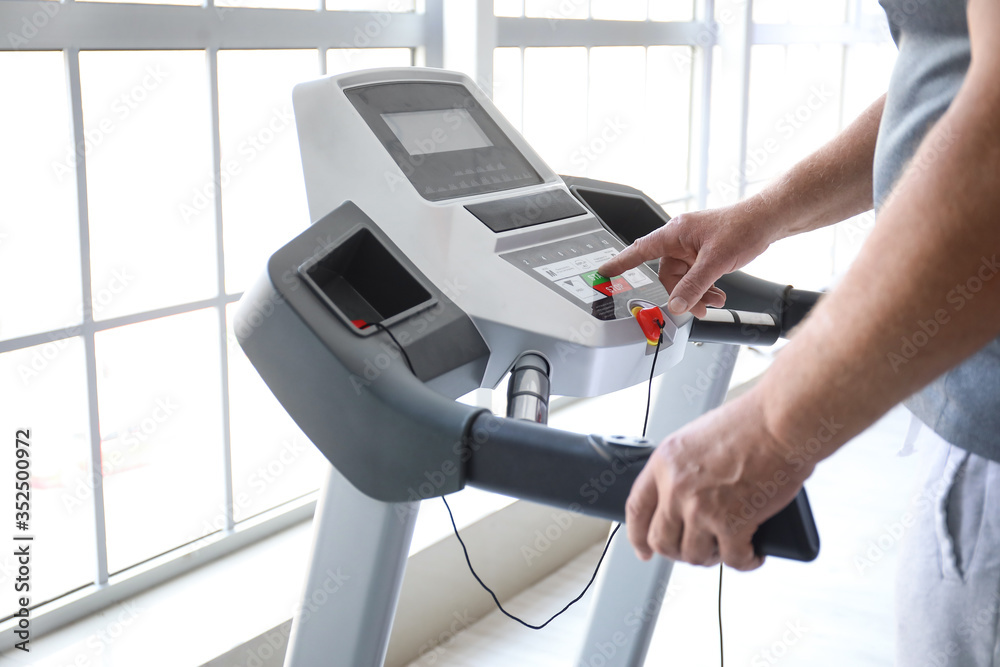 Senior man training on treadmill in gym