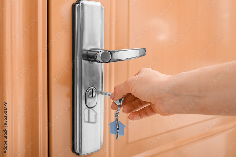 Woman opening door with key, closeup