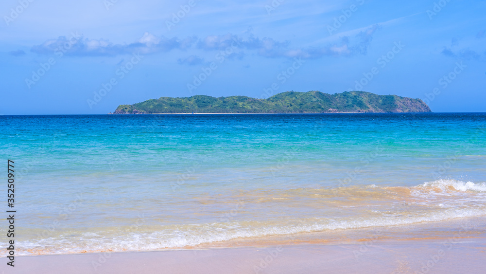 Beautiful amazing gold colored sandy beach with soft waves isolated with sunny blue sky. Concept of 